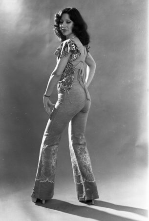 Vintage uk. portrait photo of Woman wearing embroidered flared denim trousers, 1976