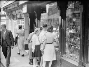 40s Ladies Fashion-Young men and women look in the window of a jeweller's shop on Silver Street in Durham, England, UK, 1943