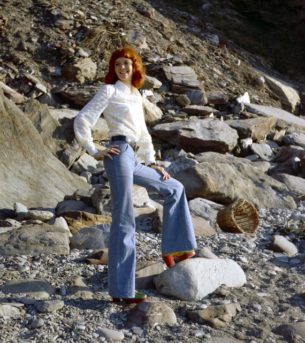 1970s Vintage clothing online- Rehead model in white blouse and bell bottom jeans, Devon, UK, 1970s.