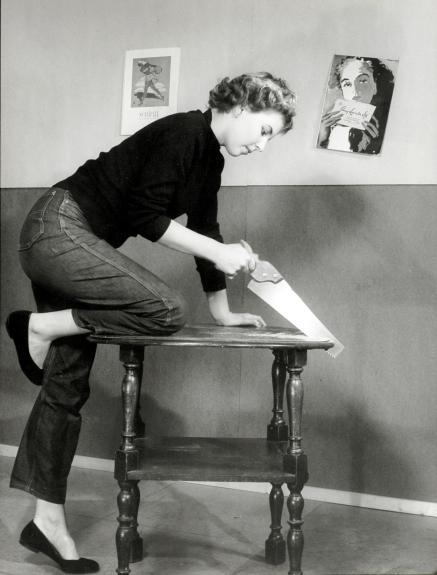 What work clothing always stays fashionable - Woman in jeans sawing a coffee table, c 1950s What work clothing always stays fashionable - Woman in jeans sawing a coffee table, c 1950s