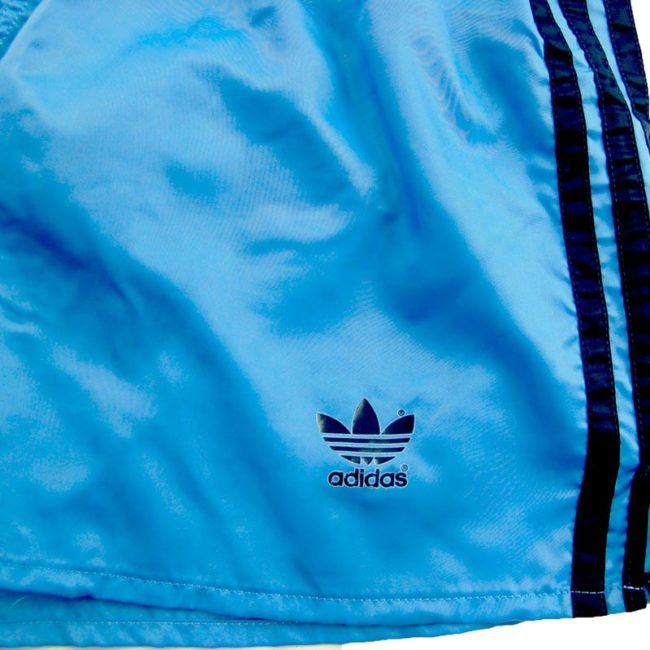 front of 90s Adidas Blue Shorts