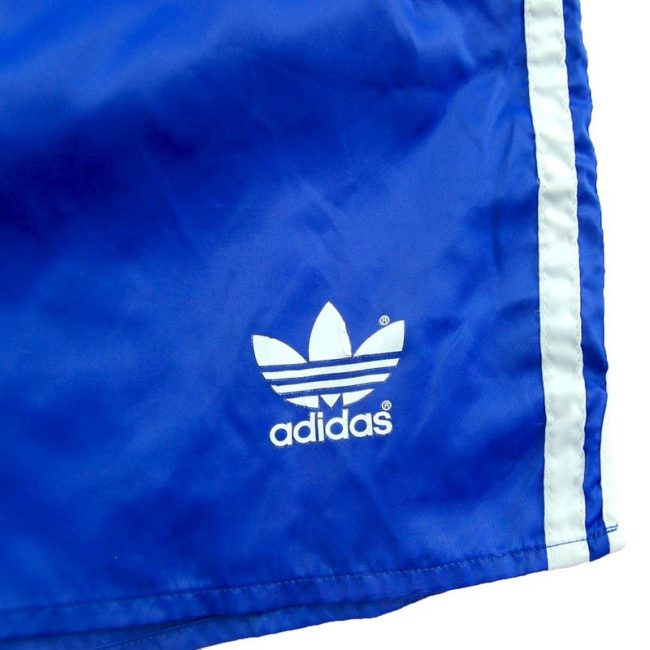 front of 90s Adidas Satin Blue Shorts