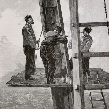 French chore jackets with construction workers standing on an elevated platform on the Eiffel Tower, 1889