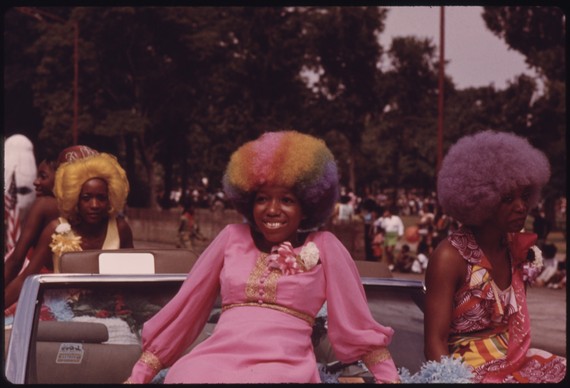 Three women in Afro wigs ride on car in the Bud Billiken Parade, Chicago, 1973 Three women in Afro wigs ride on car in the Bud Billiken Parade, Chicago, 1973