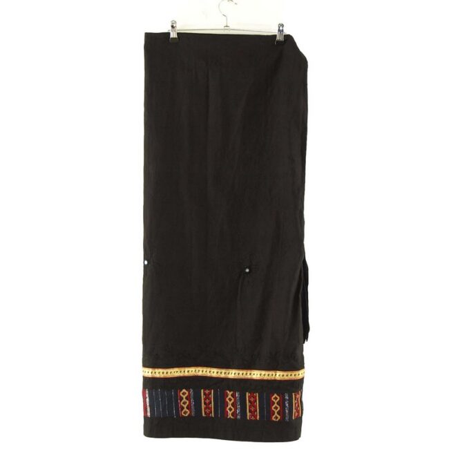 Features black cotton fabric with ribbon trim and embroidery around the hem and embroidered flowers with mirror embellishment around the centre