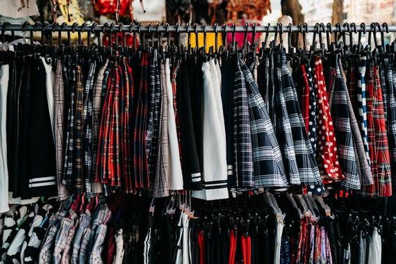 A rack of various 90s-inspired mini skirts including plaid, sequin, and denim styles