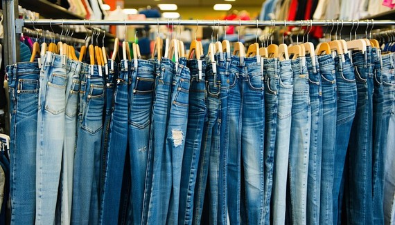 Racks of vintage denim jeans in a thrift store, showcasing a variety of styles and washes from the 90s era Racks of vintage denim jeans in a thrift store, showcasing a variety of styles and washes from the 90s era